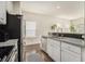 Well-lit kitchen with white cabinets, stainless steel appliances, granite counters, and dark hardwood floors at 1884 Plainsboro Drive Dr, Lithonia, GA 30058