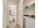 Convenient laundry area with washer, dryer, and storage shelves, adjacent to an ensuite bathroom at 1884 Plainsboro Drive Dr, Lithonia, GA 30058