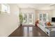 Bright living room with hardwood floors, a gray sofa, and natural light from the windows and doors at 1884 Plainsboro Drive Dr, Lithonia, GA 30058
