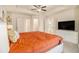 Large main bedroom with en-suite bathroom and closet; features a ceiling fan, and TV on a white dresser at 1884 Plainsboro Drive Dr, Lithonia, GA 30058
