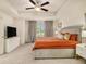 Bright bedroom with a tray ceiling, ceiling fan, large window, and an adjacent bathroom at 1884 Plainsboro Drive Dr, Lithonia, GA 30058