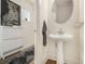 Stylish powder room featuring pedestal sink, decorative mirror, and modern accent furniture at 1884 Plainsboro Drive Dr, Lithonia, GA 30058