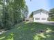 Back exterior showcasing a white-sided home, multi-car garage and treelined property at 301 Jetta Ln, Canton, GA 30115