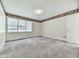 Spacious bedroom with neutral carpet, a window, and a white door and decorative border at 301 Jetta Ln, Canton, GA 30115
