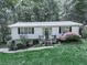 Home's front exterior with green lawn, shrubbery, and steps leading to entry door at 301 Jetta Ln, Canton, GA 30115