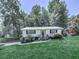 Charming single-story home with mature trees, lush lawn, and welcoming front entrance at 301 Jetta Ln, Canton, GA 30115