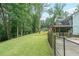 Sprawling backyard featuring a lawn, patio, and deck, surrounded by lush trees and landscaping at 58 First Manassas E Way, Sharpsburg, GA 30277