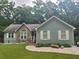 Charming single-Gathering home featuring stone accents, light green siding, and a well-manicured lawn at 58 First Manassas E Way, Sharpsburg, GA 30277