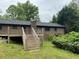 Brick house backyard featuring a wooden deck and stairs, surrounded by mature trees at 7235 Thornhill Ne Ln, Atlanta, GA 30328
