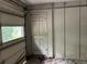 Garage area with paneled walls, access door, and partially open garage door showcasing the home's potential at 7235 Thornhill Ne Ln, Atlanta, GA 30328