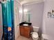 Bright bathroom featuring a black granite countertop, oak cabinetry, and playful ocean-themed shower curtain at 7326 Leland Ln, Jonesboro, GA 30236