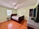 Cozy bedroom with hardwood floors, ceiling fan, and a bed bathed in natural light from the window at 7326 Leland Ln, Jonesboro, GA 30236