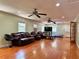 Spacious living room with hardwood floors, comfortable leather seating, and multiple ceiling fans at 7326 Leland Ln, Jonesboro, GA 30236