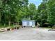 Charming light-blue shed with double doors and a variety of potted plants and garden features at 7326 Leland Ln, Jonesboro, GA 30236