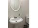 Charming half-bathroom featuring a pedestal sink, toilet, and oval mirror at 1263 Brookstone Rd, Atlanta, GA 30349