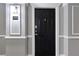 Unit 2304's black door with decorative trim and hallway wall sconce at 1850 Cotillion Dr # 2304, Dunwoody, GA 30338