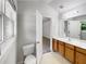 Well-lit bathroom with wood cabinets, a large mirror, and a white toilet at 2031 Austin Park Cir, Decatur, GA 30032