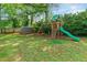 Spacious backyard featuring grass, trees, a storage shed, and a playset with slide and swings at 2146 Chevy Chase Ln, Decatur, GA 30032