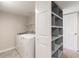 Laundry area with washer, dryer, shelving, tile flooring, and a nearby built-in shelf at 2146 Chevy Chase Ln, Decatur, GA 30032