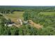 Aerial view of a stunning property with a green-roofed home, expansive lawns, and lush trees at 220 Mountain Creek Rd, Bowdon, GA 30108