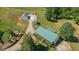 Aerial shot showcases a home with a green roof, adjacent outbuildings, and well-maintained landscaping at 220 Mountain Creek Rd, Bowdon, GA 30108