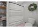 Well-organized bathroom with a shower curtain, toilet, and shelving for storage and a decorative wreath at 220 Mountain Creek Rd, Bowdon, GA 30108