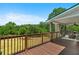 Wide angle view of the deck overlooking a wooded area with ceiling fan and seating area with chairs and small table at 220 Mountain Creek Rd, Bowdon, GA 30108