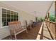 Spacious front porch with wooden railings and multiple rocking chairs offers a relaxing outdoor space at 220 Mountain Creek Rd, Bowdon, GA 30108