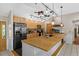Modern kitchen featuring a large island, stainless steel appliances, stylish lighting, and vaulted ceiling at 220 Mountain Creek Rd, Bowdon, GA 30108