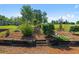 Multi-tiered landscaping with retaining wall featuring green bushes and a mulch bed at 220 Mountain Creek Rd, Bowdon, GA 30108