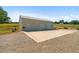 View of the side of the outbuilding, with large parking area and tractor at 220 Mountain Creek Rd, Bowdon, GA 30108