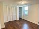 Bedroom features wood-look floors, closet, and bright window with a view of the yard at 1028 Gate Post Ln, Lawrenceville, GA 30044