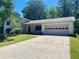 Charming home featuring an attached garage, a well-manicured lawn, and a classic driveway at 1028 Gate Post Ln, Lawrenceville, GA 30044