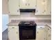 Close up view of oven, stove, overhead vent, granite counters, and white painted cabinets in the kitchen at 1028 Gate Post Ln, Lawrenceville, GA 30044