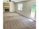 Spacious living room featuring a stone fireplace, ceiling fan, and new neutral colored carpet at 1028 Gate Post Ln, Lawrenceville, GA 30044
