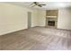 Large living room featuring a stone fireplace, ceiling fan, neutral colored carpet, and white wainscoting at 1028 Gate Post Ln, Lawrenceville, GA 30044