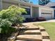 Exterior shot of stone steps leading to the home with a meticulously landscaped yard at 1028 Gate Post Ln, Lawrenceville, GA 30044