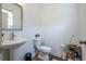 Neat half bathroom with modern fixtures, pedestal sink, toilet, and wooden vinyl flooring at 3518 Mount Blue Ave, Tucker, GA 30084