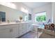 Elegant bathroom featuring double vanity, soaking tub with window, and plentiful counter space at 3518 Mount Blue Ave, Tucker, GA 30084