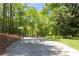 Long driveway leading up to an iron gate with an American flag creating a private entry at 390 Rock Springs Pass, Dallas, GA 30157