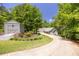 Beautiful home with long driveway, gray exterior and spacious shed surrounded by mature trees and flowers at 390 Rock Springs Pass, Dallas, GA 30157