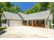 Charming single-story home featuring a spacious porch, two-car garage, and professionally landscaped front yard at 390 Rock Springs Pass, Dallas, GA 30157