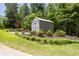Storage shed in landscaped yard with healthy lawn and plants at 390 Rock Springs Pass, Dallas, GA 30157