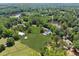 Wide aerial view of an estate featuring a pond, fenced pastures, outbuildings and mature trees at 471 Henderson Lake Dr, Canton, GA 30115