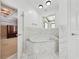 Large soaking tub surrounded by marble tile next to walk-in closet at 471 Henderson Lake Dr, Canton, GA 30115