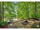 Lakeside fire pit area with built-in seating, a dock, and lush greenery at 471 Henderson Lake Dr, Canton, GA 30115