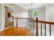 Upstairs hallway landing with chandelier, hardwood floors, and open view to first floor at 471 Henderson Lake Dr, Canton, GA 30115