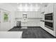 Modern kitchen with stainless steel appliances, white cabinetry, and beautiful stone flooring at 471 Henderson Lake Dr, Canton, GA 30115