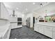 Modern kitchen with white cabinets, stainless steel appliances, and tile flooring open to living area at 471 Henderson Lake Dr, Canton, GA 30115