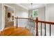 Second floor landing with wood floors, black wrought iron railing, chandelier, and window at 471 Henderson Lake Dr, Canton, GA 30115